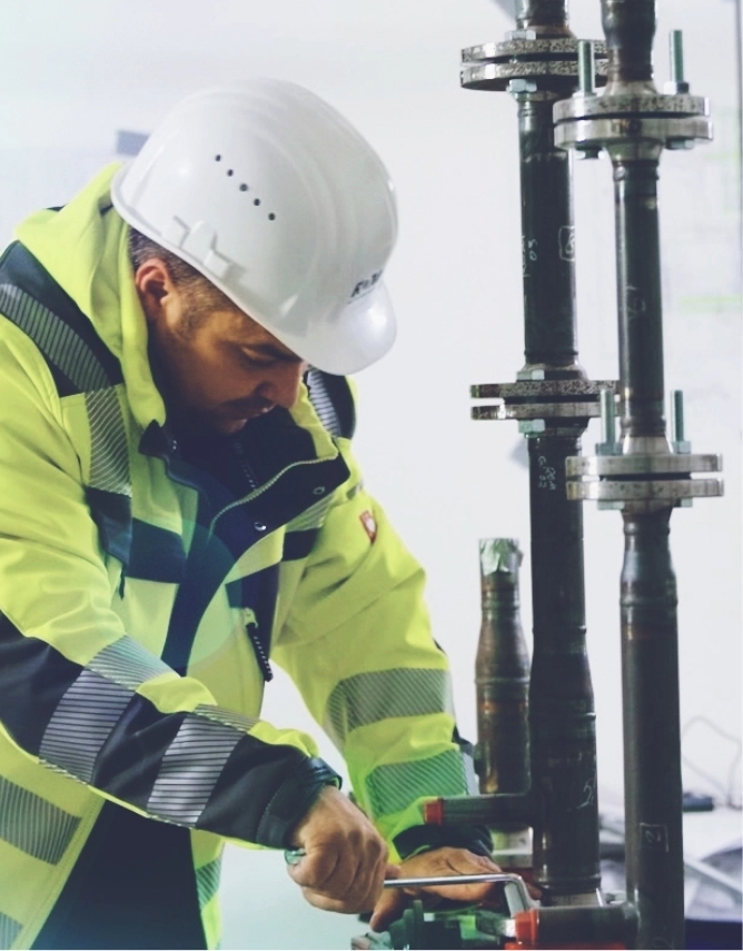 Ein Techniker von ROM Technik erledigt Wartungsarbeiten an einer Anlage der TGA in einem gewerblich genutzten Gebäude.